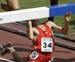 A man falling and hitting himself on a hurdle